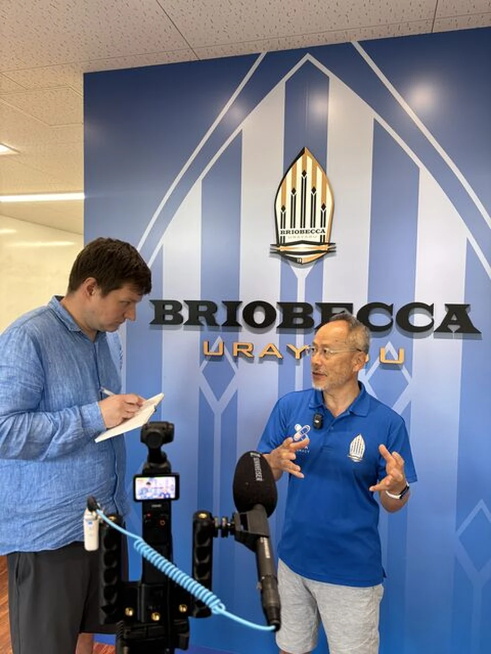 Dmitry interpreting during filming with Briobecca Urayasu general director Kazushi Taniguchi